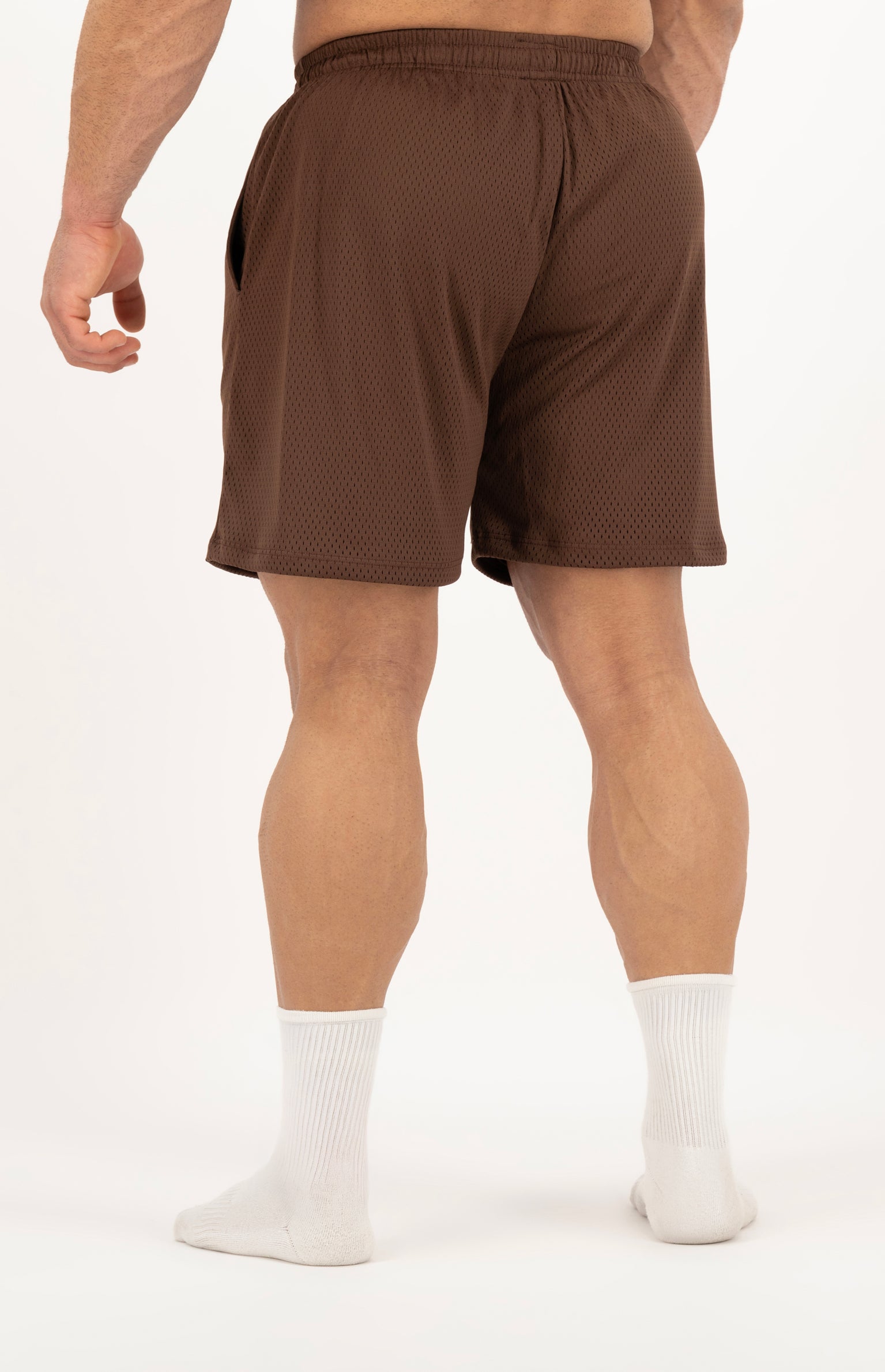 Brown athletic shorts worn by a person on a white background