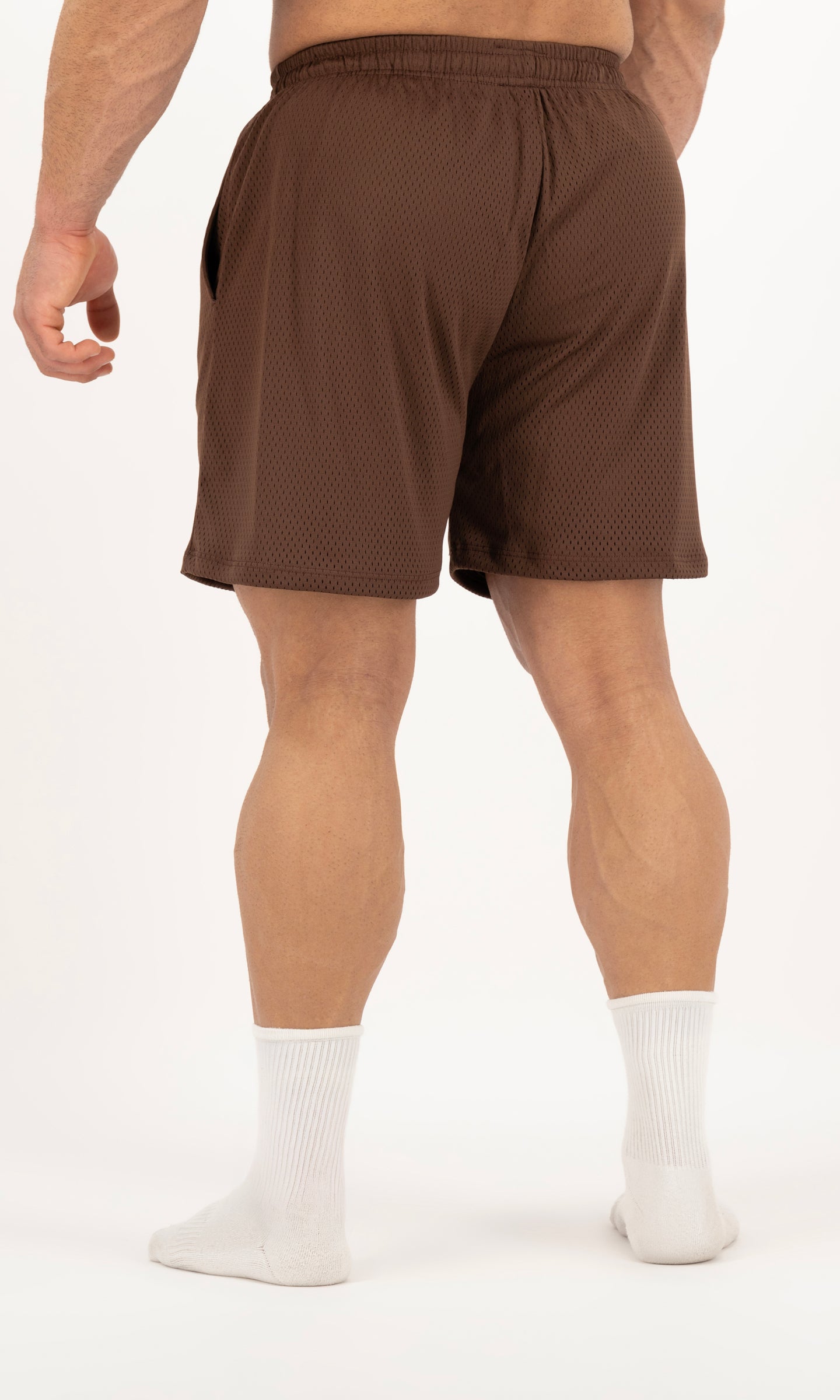 Brown athletic shorts worn by a person on a white background